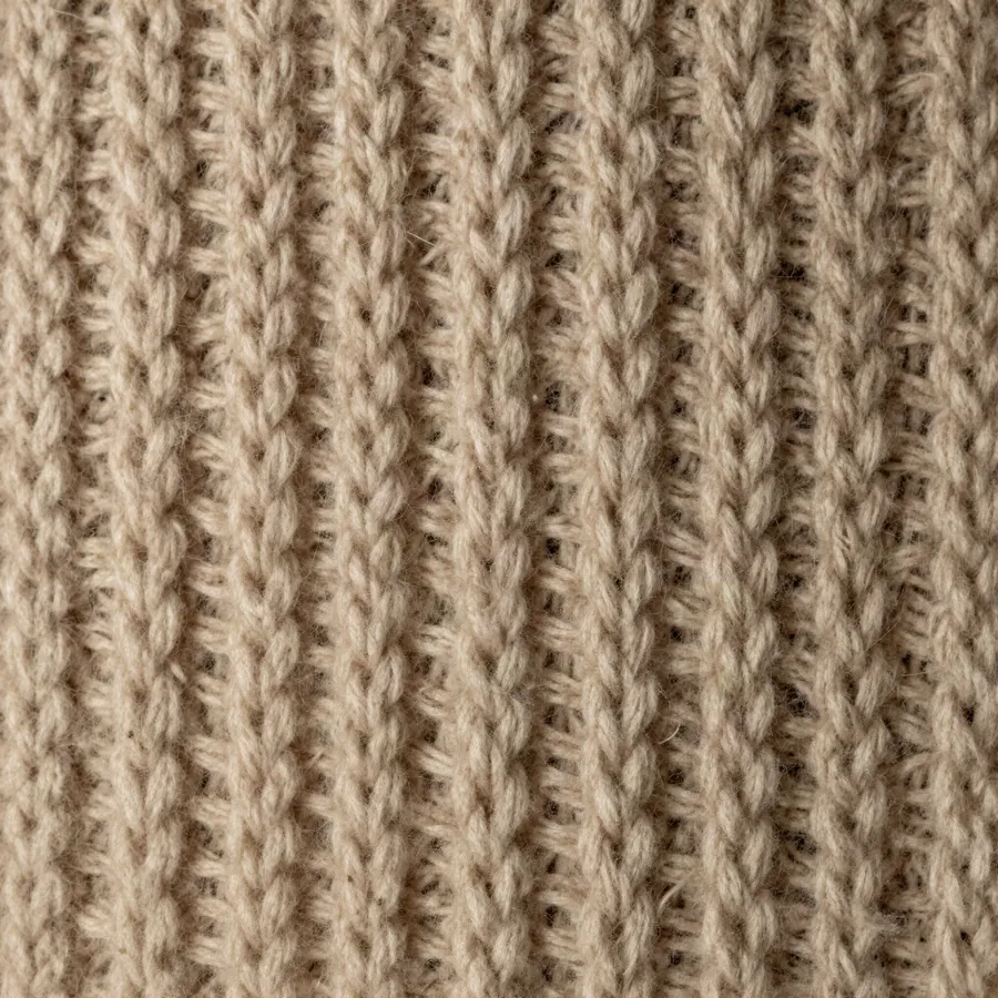 Detalle macro del tejido grueso de lana en tono avena